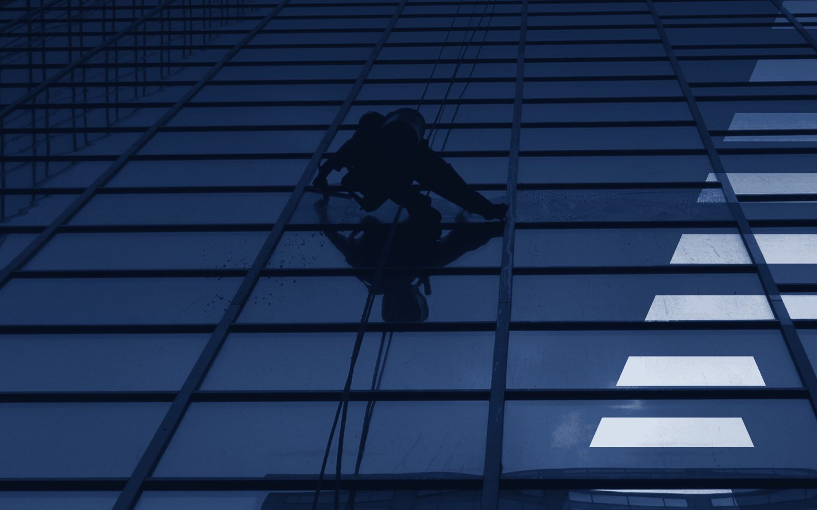 Rope access technician on a glass façade